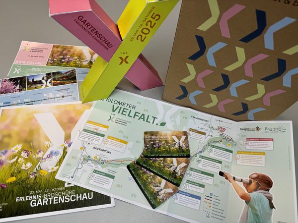 Das ideale Geschenk für sich und andere: Die Dauerkarte der Gartenschau 2025 erhältlich ab 04. Oktober 2024 - auf dem Bild die Dauerkarte, die Geschenkverpackung, die Geschenktasche und der neue Flyer